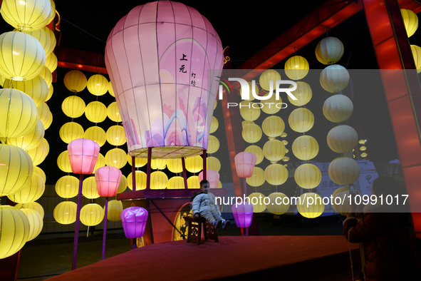 A child is posing under lanterns at the Bali Lake Spring Festival in Jiujiang, Jiangxi province, China, on February 12, 2024. 