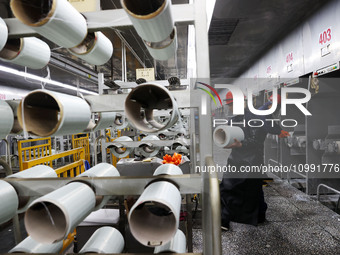 A worker is performing a wire-drawing operation at the production workshop of a glass fiber company in Chongqing, China, on February 11, 202...