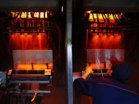 A worker is performing a wire-drawing operation at the production workshop of a glass fiber company in Chongqing, China, on February 11, 202...