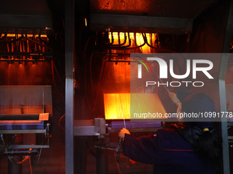 A worker is performing a wire-drawing operation at the production workshop of a glass fiber company in Chongqing, China, on February 11, 202...