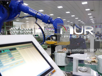 A robot is transferring glass fiber products at the production workshop of a glass fiber company in Chongqing, China, on February 11, 2024....