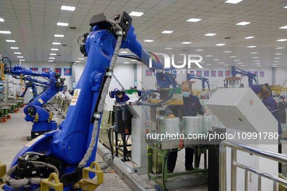 A robot is transferring glass fiber products at the production workshop of a glass fiber company in Chongqing, China, on February 11, 2024. 