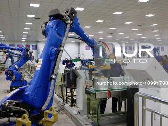 A robot is transferring glass fiber products at the production workshop of a glass fiber company in Chongqing, China, on February 11, 2024....