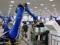 A robot is transferring glass fiber products at the production workshop of a glass fiber company in Chongqing, China, on February 11, 2024....