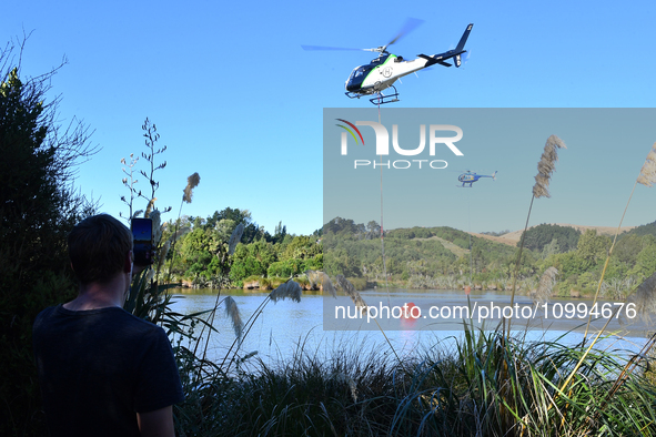 Fire-fighting helicopters are filling up with water at the scene of a fire in Christchurch, New Zealand, on February 14, 2024. A local state...