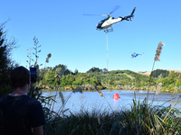 Fire-fighting helicopters are filling up with water at the scene of a fire in Christchurch, New Zealand, on February 14, 2024. A local state...