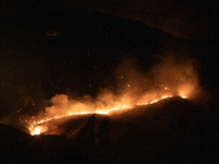 Flames are rising while efforts to extinguish the wildfire that broke out in Port Hills, Christchurch, New Zealand, on February 14, 2024, co...