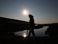 A boy is walking on the dried portion of Wular Lake in the Ningli area of Sopore District, Baramulla, Jammu and Kashmir, India, on February...