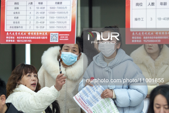 Job seekers are looking at job requirements at the 2024 Spring Festival human resources trade fair in Haian, East China's Jiangsu province,...