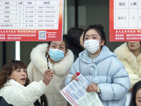 Job seekers are looking at job requirements at the 2024 Spring Festival human resources trade fair in Haian, East China's Jiangsu province,...