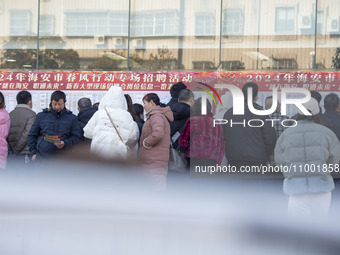 Job seekers are looking at job requirements at the 2024 Spring Festival human resources trade fair in Haian, East China's Jiangsu province,...