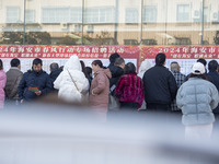 Job seekers are looking at job requirements at the 2024 Spring Festival human resources trade fair in Haian, East China's Jiangsu province,...