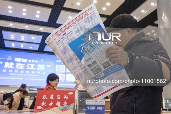 Job seekers are looking at job requirements at the 2024 Spring Festival human resources trade fair in Haian, East China's Jiangsu province,...