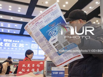 Job seekers are looking at job requirements at the 2024 Spring Festival human resources trade fair in Haian, East China's Jiangsu province,...