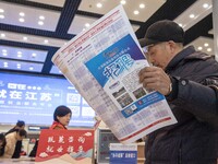 Job seekers are looking at job requirements at the 2024 Spring Festival human resources trade fair in Haian, East China's Jiangsu province,...