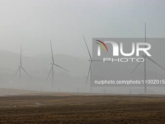 Wind turbines are standing under a sandstorm in Yongchang, Gansu Province, China, on February 17, 2024. (