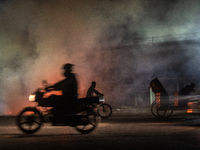 City dwellers are passing by a garbage fire on a busy road in Dhaka, Bangladesh, on February 17, 2024. Five of the top 10 causes of death in...