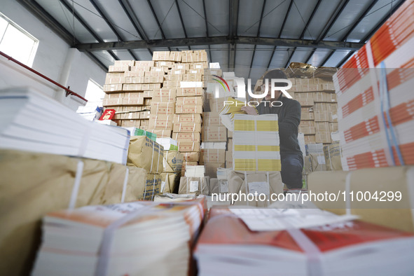 Staff members are distributing new teaching materials at the storage and transportation center of Xinhua Bookstore in Suqian, Jiangsu provin...