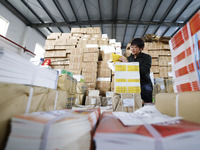 Staff members are distributing new teaching materials at the storage and transportation center of Xinhua Bookstore in Suqian, Jiangsu provin...