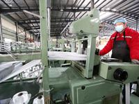 A worker is producing textile products at a workshop of a production enterprise in the Lianyun district, Lianyungang City, China, on Februar...