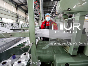 A worker is producing textile products at a workshop of a production enterprise in the Lianyun district, Lianyungang City, China, on Februar...