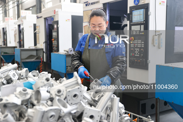 A worker is producing auto parts at a company in Lianyungang, China, on February 18, 2024. 