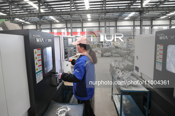 A worker is producing auto parts at a company in Lianyungang, China, on February 18, 2024. 