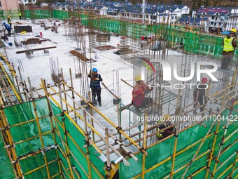 Workers are working at the construction site of a resettlement area project in Yuexi County, Anqing, China, on February 18, 2024. (