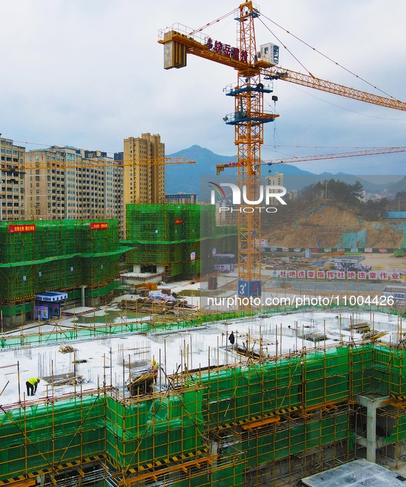 Workers are working at the construction site of a resettlement area project in Yuexi County, Anqing, China, on February 18, 2024. 