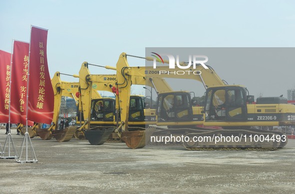 Construction workers are driving an excavator to start construction of the main campus of the Hangzhou Institute for Advanced Studies at the...