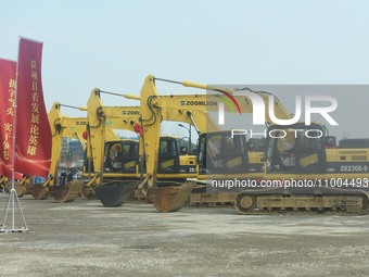 Construction workers are driving an excavator to start construction of the main campus of the Hangzhou Institute for Advanced Studies at the...