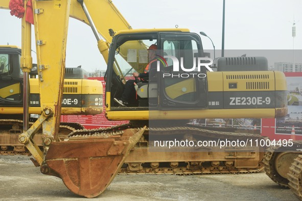 Construction workers are driving an excavator to start construction of the main campus of the Hangzhou Institute for Advanced Studies at the...