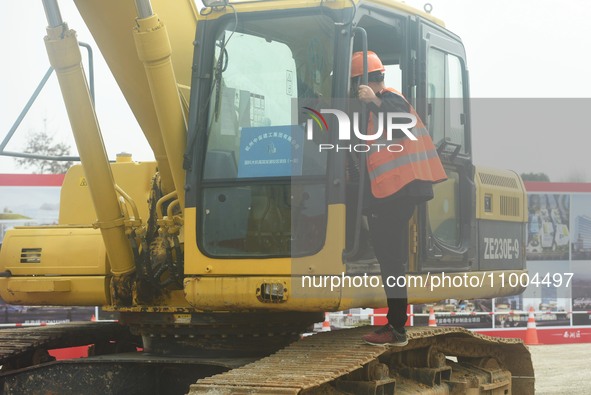 Construction workers are walking into an excavator to start it during the opening ceremony of the main campus of the Hangzhou Institute for...