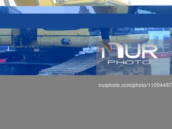 Construction workers are walking into an excavator to start it during the opening ceremony of the main campus of the Hangzhou Institute for...