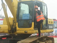 Construction workers are walking into an excavator to start it during the opening ceremony of the main campus of the Hangzhou Institute for...