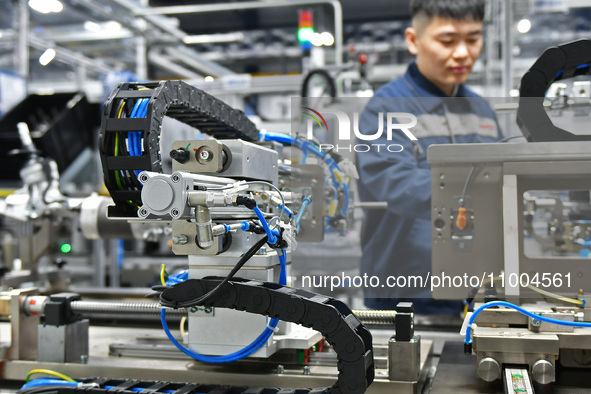 A worker is producing a steering machine at a workshop of an auto parts company in Yantai, China, on February 18, 2024. 