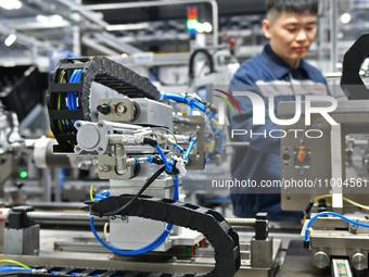 A worker is producing a steering machine at a workshop of an auto parts company in Yantai, China, on February 18, 2024. (