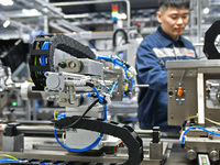 A worker is producing a steering machine at a workshop of an auto parts company in Yantai, China, on February 18, 2024. (