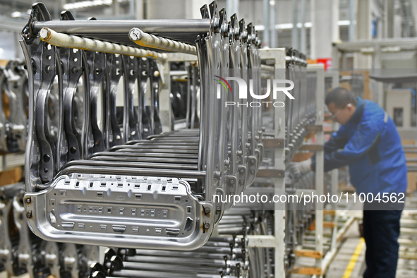 A worker is conducting a product quality inspection at a workshop of an auto parts company in Yantai, China, on February 18, 2024. 