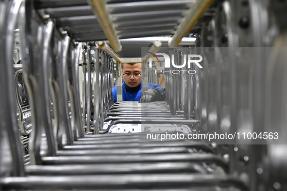 A worker is conducting a product quality inspection at a workshop of an auto parts company in Yantai, China, on February 18, 2024. 