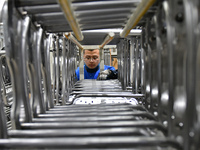 A worker is conducting a product quality inspection at a workshop of an auto parts company in Yantai, China, on February 18, 2024. (