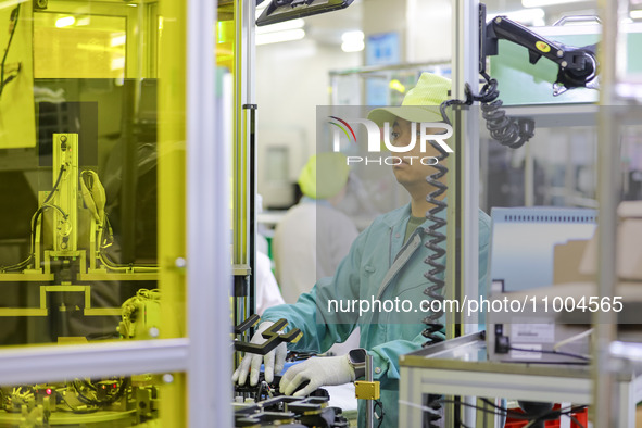 A worker is working in a workshop at an automotive electronics company in Qingdao, Shandong Province, China, on February 18, 2024. 