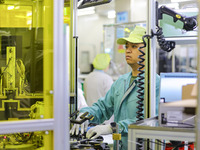 A worker is working in a workshop at an automotive electronics company in Qingdao, Shandong Province, China, on February 18, 2024. (