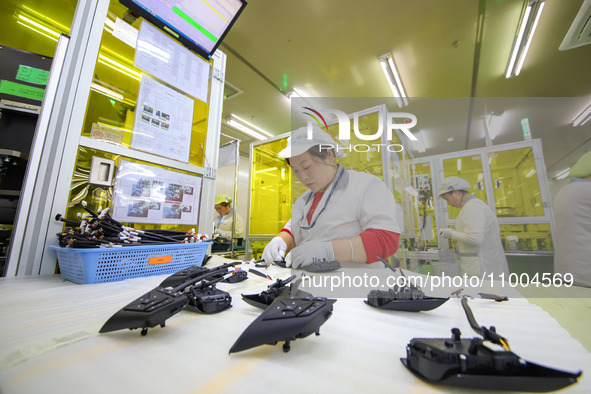 A worker is setting up wiring harnesses in a workshop of an automotive electronics company in Qingdao, China, on February 18, 2024. 