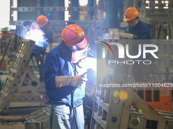 Workers are performing welding at the production workshop of Nanjing Changjiang Industrial Furnace Technology Group Co., Ltd. in Nanjing, Ji...