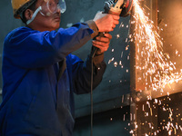 A worker is grinding at the production workshop of Nanjing Changjiang Industrial Furnace Technology Group Co., Ltd. in Nanjing, Jiangsu Prov...