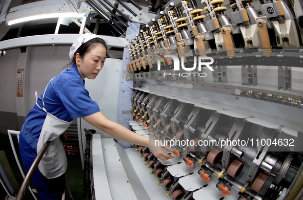 A worker is inspecting production at a workshop of a chemical fiber company in Suqian, East China's Jiangsu province, on February 18, 2024. 