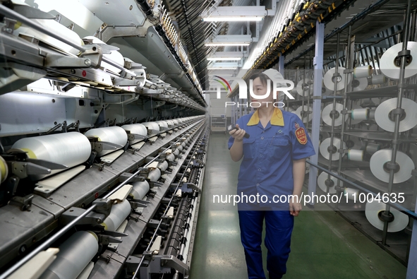 A worker is inspecting production at a workshop of a chemical fiber company in Suqian, East China's Jiangsu province, on February 18, 2024. 