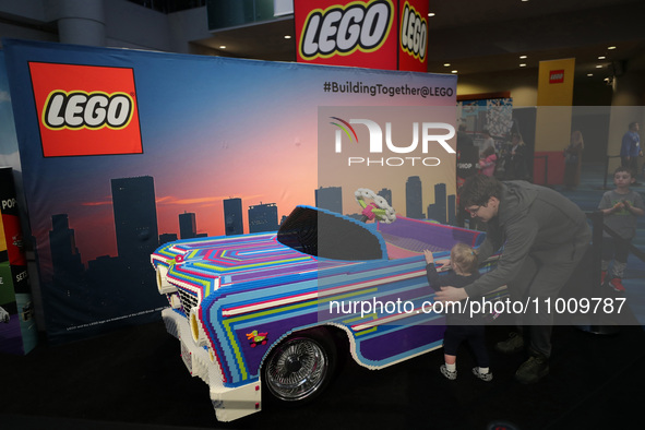 People are looking at a car made of LEGO bricks at the Canadian International Auto Show in Toronto, Canada, on February 19, 2024. 
