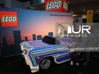 People are looking at a car made of LEGO bricks at the Canadian International Auto Show in Toronto, Canada, on February 19, 2024. (